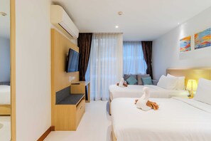 A hotel room with two beds, a TV, a desk, and a window with curtains. - Steps from the Beach Pool View C245 (Rawai)