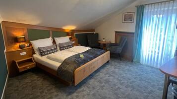 Une chambre à coucher comprenant un lit, des tables de chevet, un bureau et une chaise.