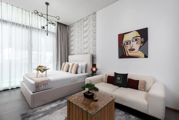 Ein modernes Schlafzimmer mit Bett, Sofa, Couchtisch und einem Gemälde an der Wand.