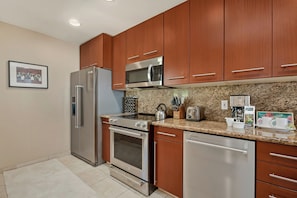 A modern kitchen with stainless steel appliances and granite countertops, perfect for prepping your vacation meals. KGV-20T8 - Kapalua Golf | Golf View 3 BR, Sleeps 11 | Car Incl. w/ 6+ Nights | KGV ML-2303 by KBM (Lahaina)