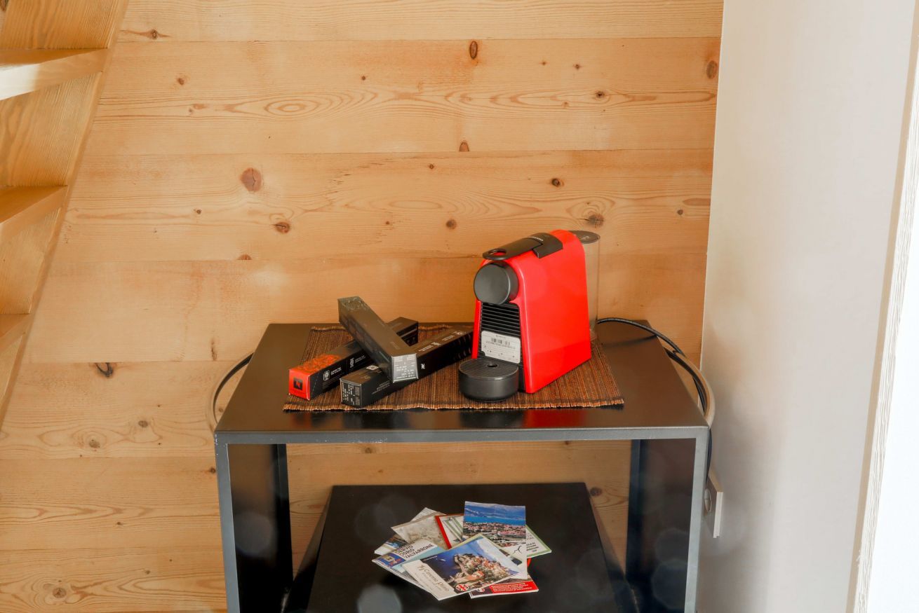 A small table with a red device and a black device on top, and a magazine on the table below.