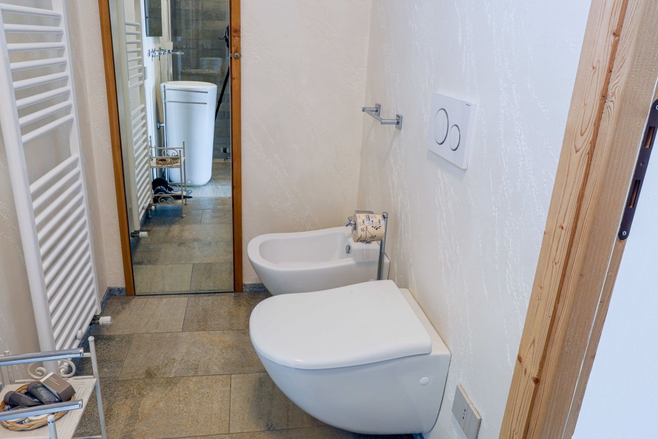 Une salle de bain équipée de toilettes, d’un bidet et d’un porte-serviettes.