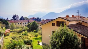 A residential area with houses, a well-maintained garden, and mountains in the background. - Green Chalet - Wonderfull terrace lake view - Jacuzzi and SPA  (Dervio)