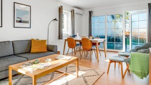 A modern living room with a sofa, coffee table, and dining area with chairs. - "Ama" - 350m from the sea by Interhome (Læsø)