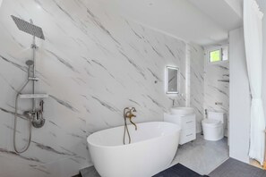 A modern bathroom with a freestanding bathtub, a handheld showerhead, a vanity with a mirror, and a toilet. - Modern 10BR ZipLine 3 Pools  V256 (Rawai)