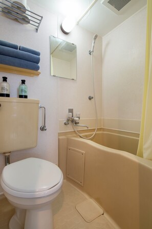 Ein Badezimmer mit Toilette, Badewanne und Dusche.