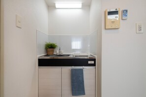 Ein modernes Badezimmer mit Waschbecken, Spiegel und Handtuchhalter.
