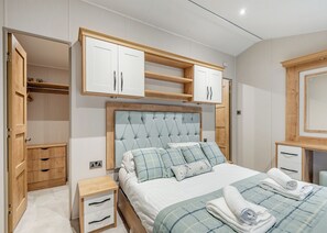 A bedroom with a bed, bedside tables, a wardrobe, and built-in shelves. - 2 bedroom accommodation in Bala, (Bala,)