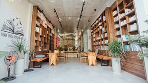A bookstore with wooden shelves, a central table, and potted plants. - Celia Boutique Hotel Phong Nha (Son Trach)
