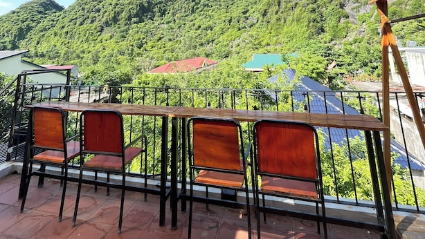 A wooden sign with "Céleste Boutique Hotel" and a view of green mountains. - Celia Boutique Hotel Phong Nha (Son Trach)