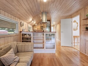 A cozy interior with a wooden ceiling, a sofa, a kitchen area with cabinets, and a view through a window. - "Athislus" - 1.1km from the sea by Interhome (Glesborg)