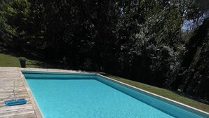 A rectangular swimming pool with clear blue water, surrounded by a wooden deck. - Detached studio with terrace in Aix countryside property (Aix-en-Provence)