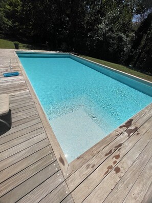 A rectangular swimming pool with clear blue water, surrounded by a wooden deck. - Detached studio with terrace in Aix countryside property (Aix-en-Provence)