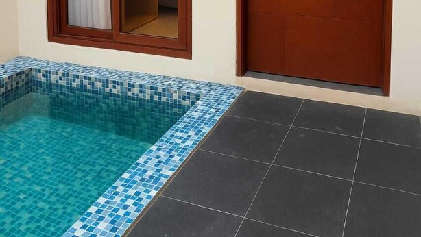 Ein Zimmer mit einem kleinen Pool, einer Tür und einem Fenster mit Vorhang.