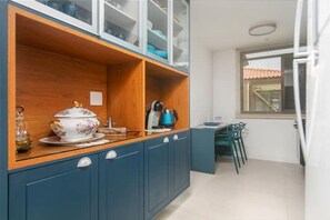 A compact kitchen with a wooden countertop, a coffee maker, and a dining area with a table and chairs. - Villa Pérola do Aré · Heated and private Pool & Jacuzzi · Barbecue area (Armação dos Búzios)