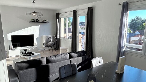 A modern living room with a black marble table, grey sofas, and a white entertainment unit. - Cosy, fully-equipped apartment (Chalon-sur-Saône)