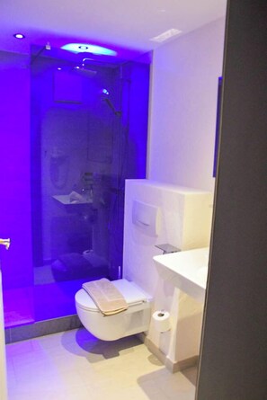 Une salle de bain moderne avec une douche, des toilettes et un lavabo blanc.