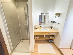 Chuveiro, secador de cabelo, toalhas de banho, sabonete