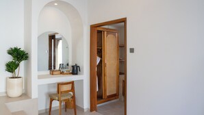 A hallway with a wooden door, a potted plant, a mirror, and a chair. - Dianatara Villa Ubud by Dhananjaya Hospitality (Celuk)