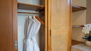 A wooden door with a white robe hanging on a rack, a woven partition, and a potted orchid on a marble surface. - Dianatara Villa Ubud by Dhananjaya Hospitality (Celuk)