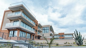 A modern multi-story building with balconies, large windows, and a landscaped area with plants. - The 67 Escape, Elementaita (Gilgil)
