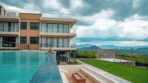 A modern hotel with a swimming pool, a stone structure, and a view of mountains. - The 67 Escape, Elementaita (Gilgil)