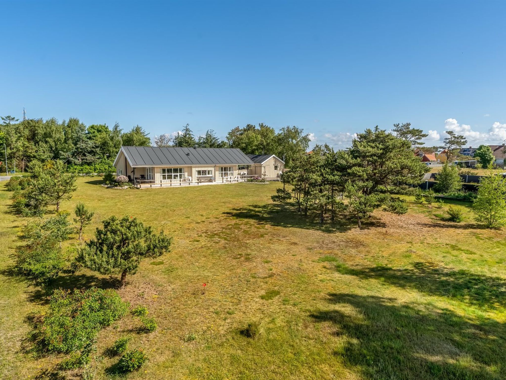 Une grande maison avec une vaste pelouse et plusieurs arbres.