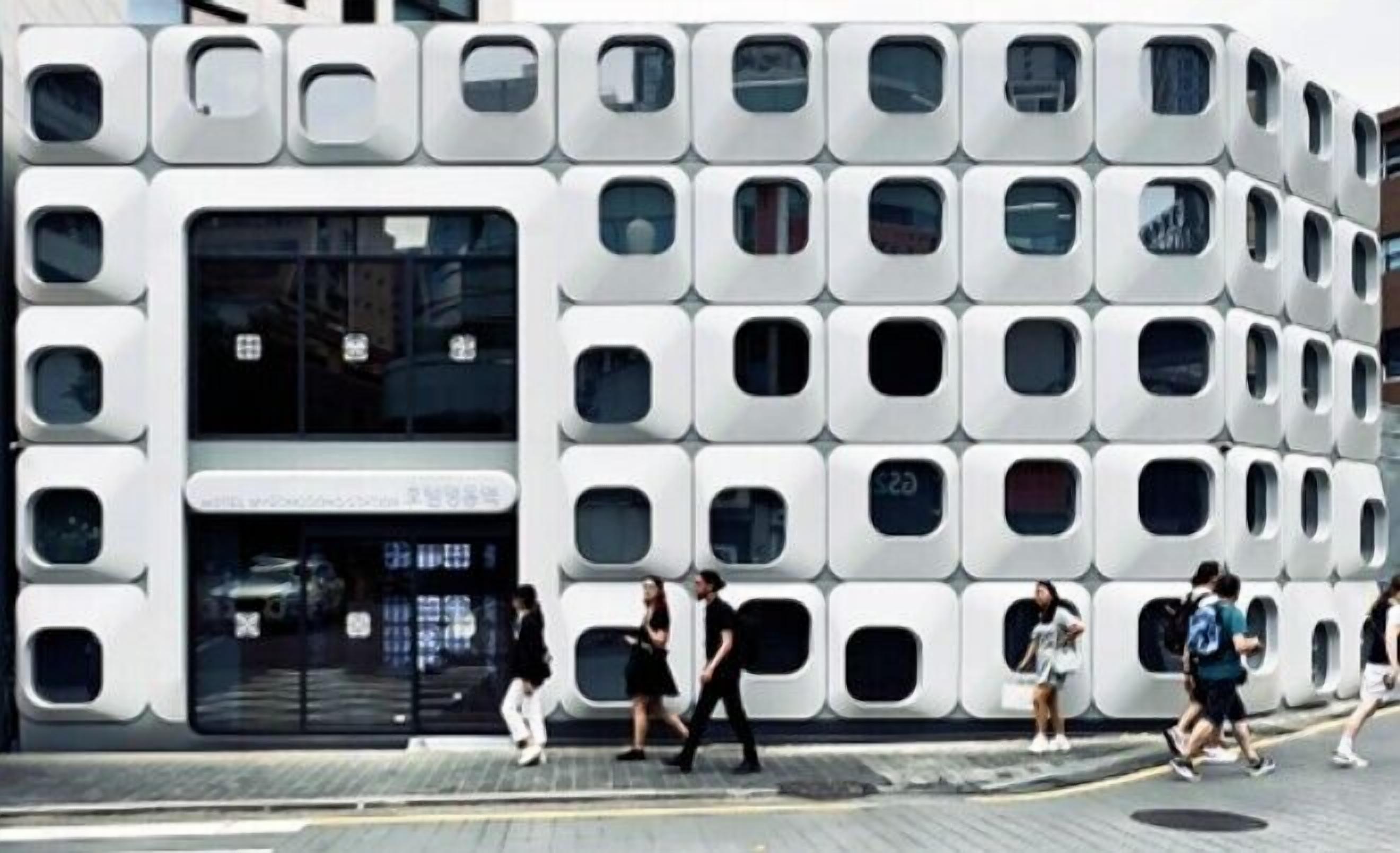 Um edifício moderno com design modular único, com várias janelas e uma entrada central.