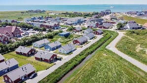 Un quartier résidentiel situé sur la côte, avec des maisons, un canal et une vue sur la mer.