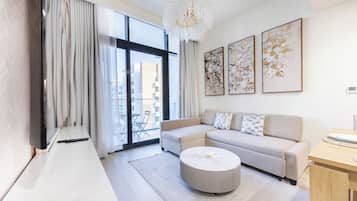 A modern living room with a sectional sofa, a round coffee table, and a large window with curtains.