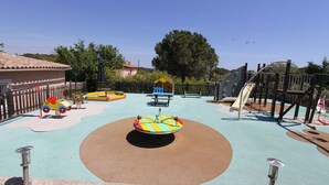 A playground with various play structures, including a slide and swings. - VILLA CARA (Mougins)