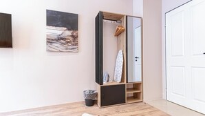 Una habitación con un armario de madera, un espejo, una tabla de surf y una alfombra de cuero.