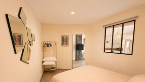 Una camera da letto con un letto, un comodino, uno specchio e un armadio.