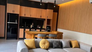 A modern living room with a grey sectional sofa, wooden coffee table, and a ceiling fan. - Guru Darma Villa Newly Built September 2025 (Taro)