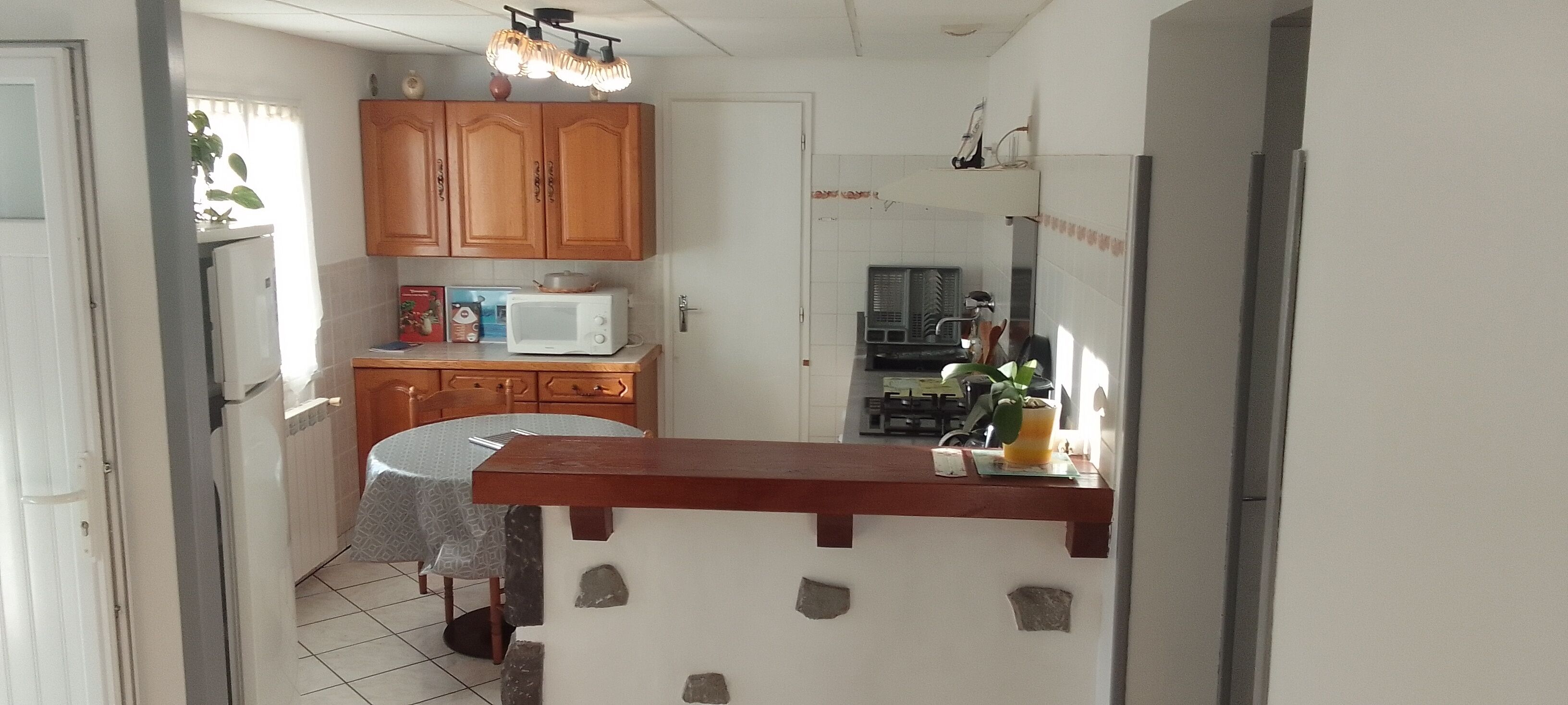A kitchen with wooden cabinets, a microwave, a stove, and a sink.