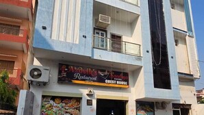 A multi-story building with a restaurant named "AxoVik's Restaurant" on the ground floor, featuring a guest house sign. - sandhya paying guest house (Varanasi)