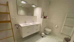 A modern bathroom with two sinks, a toilet, and a mirror. - 4-Room Apartment, 6 People, Sauna, Hammam, Parking, Wifi (Châtel)