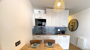 Una cucina moderna con mobili bianchi, forno integrato e macchina da caffè.