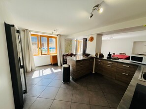 Una cocina moderna con un amplio ventanal, un microondas y un lavabo.
