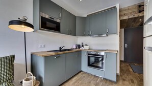A compact kitchen with grey cabinets, a built-in oven, and a wooden countertop. - 3-room Appt + Cabin 52m2 - 4ad 3children (Tignes)