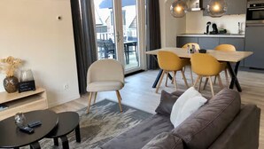 Un appartement moderne comprenant un coin repas, un canapé et une cuisine.