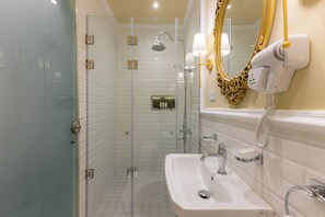 Regadera, secadora de cabello, pantuflas, toallas 