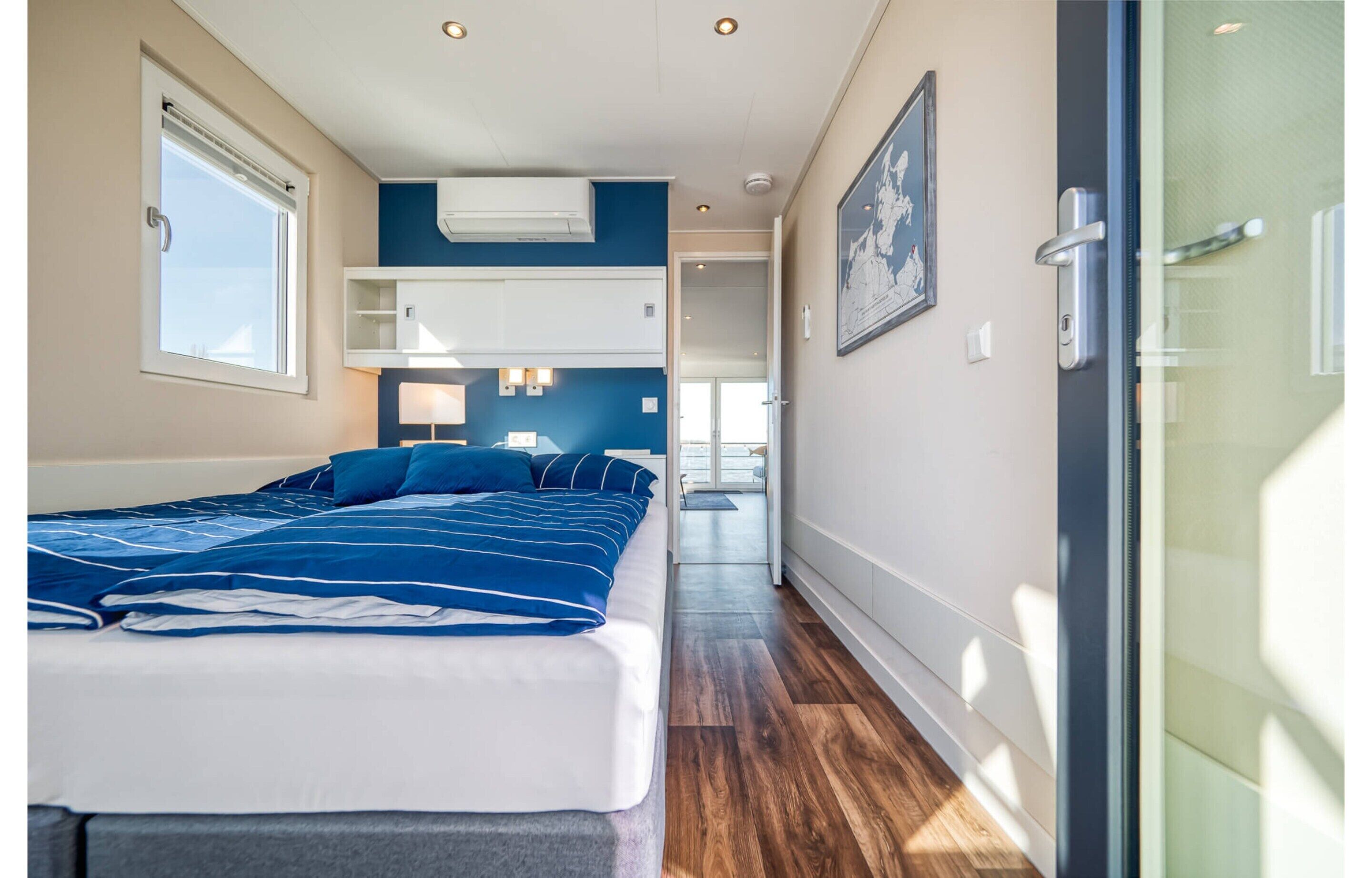 A bedroom with a bed, a window, and a door.