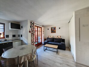 A compact living space with a kitchenette, dining area, and seating area. - Apartment 3 to 6 pers. Located 10 minutes' walk from the cable cars and thermal baths. (Cauterets)