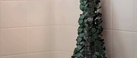 A shower with a rain showerhead and a wall-mounted control knob.