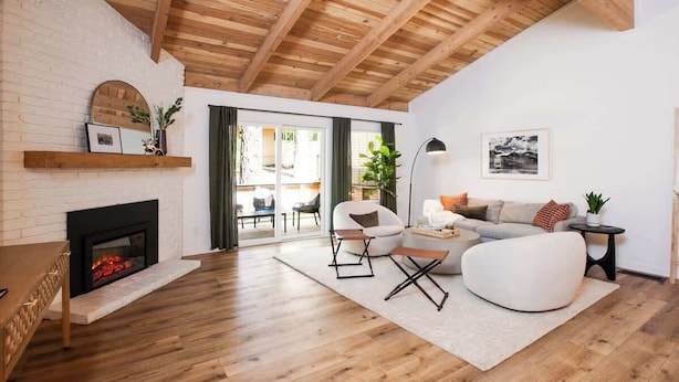 Ein modernes Wohnzimmer mit Kamin, Holzboden und einer gemütlichen Sitzecke.