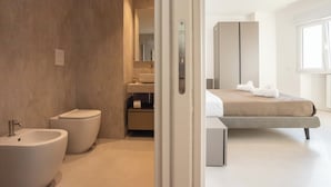 Un baño moderno con bidé, inodoro y lavamanos.