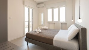 Un dormitorio moderno con una cama grande, vistas al balcón y un diseño minimalista.