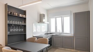 Una cocina moderna con comedor, que incluye una vinoteca empotrada, estufa a gas y un amplio ventanal que proporciona luz natural.