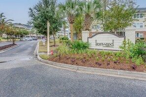 A residential area with a sign for 'Ironwood' and a landscaped garden with various plants and flowers. - Golf & Relax! Resort-style Condo in Myrtle Beach (North Myrtle Beach)